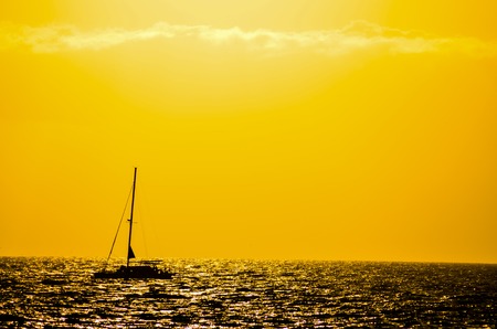 Backlight Picture of a Silhouette Boat in the Oceanの写真素材