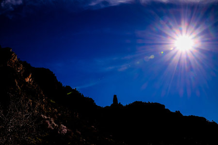 Sun Star on a Blue Sky over a Mountain Silhouette in Gran Canaria Spainの写真素材