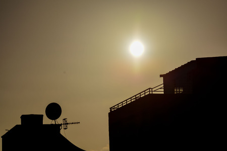 Some Silhouetted Antennas on the top of a Roofの写真素材
