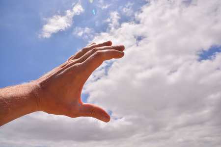Picture of an Hand over a Cloudy Skyの写真素材