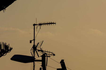 Some Silhouetted Antennas on the top of a Roofの写真素材