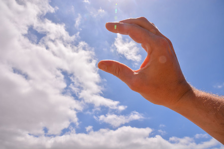 Picture of an Hand over a Cloudy Skyの写真素材