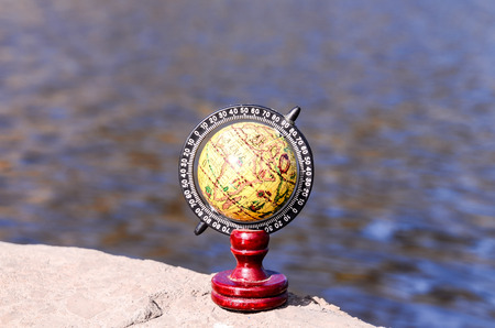 Planet Globe Earth on the Rock near the Waterの写真素材