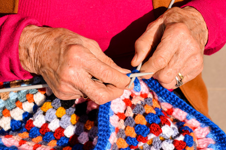 Close-up image of an old woman with knitting needles and woolの写真素材