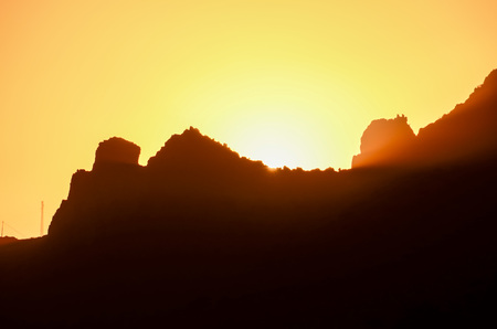 Orange Sun Setting Behind the Mountainsの写真素材