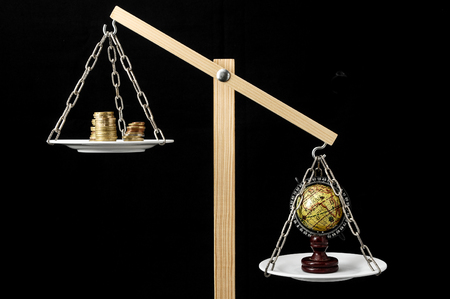 Globe Planet Earth and Money on a Two Pan Balanceの写真素材