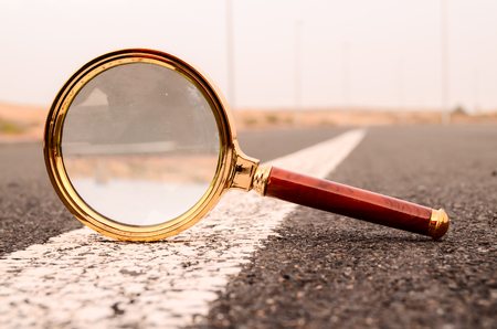 Travel Concept Magnify Glass Loupe on the Asphlat Roadの写真素材