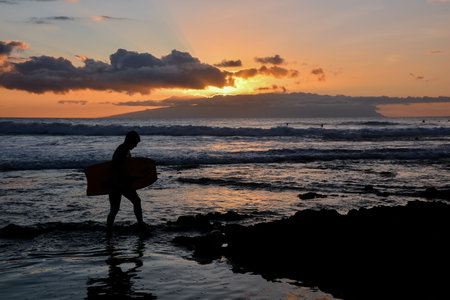 Single surfer at sunset on a calm ocean