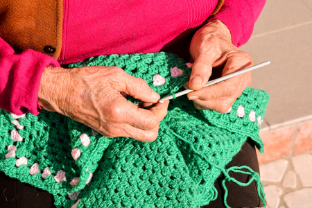 Close-up image of an old woman with knitting needles and woolの写真素材