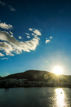 Dramatic Sunset Rays Behind Silhouette of a Mountainの写真素材