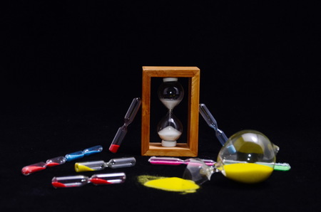 Deadline Concept Broken Hourglass with Yellow Sand on Black Backgroundの写真素材