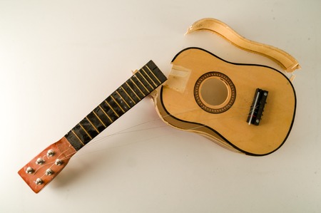 Close-up of Broken Guitar Object on a White Backgroundの写真素材
