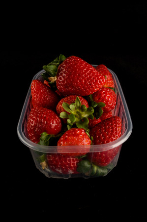 fresh strawberries in box isolated on black backgroundの写真素材