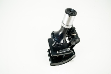 An old scientific microscope toy isolated on whiteの写真素材