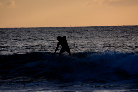 Single surfer at sunset on a calm oceanの写真素材