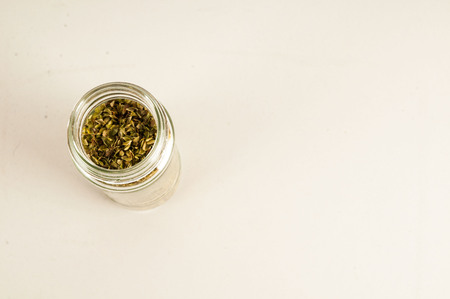 Bottle of dried oregano leaves isolated on white backgroundの写真素材