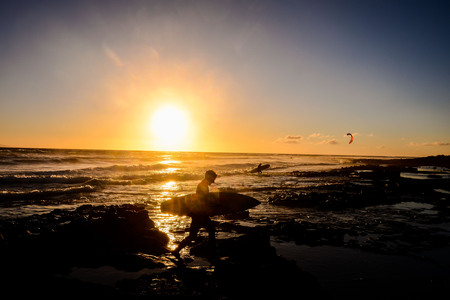 Single surfer at sunset on a calm oceanの写真素材