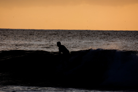 Single surfer at sunset on a calm oceanの写真素材