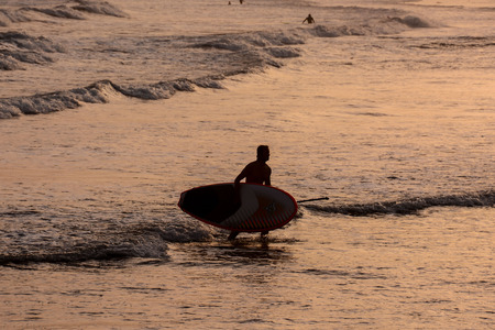 Single surfer at sunset on a calm oceanの写真素材