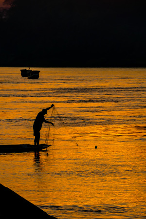 silhouette of fisherman at sunset, beautiful photo digital pictureの写真素材