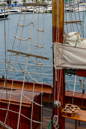 Wooden sailboat on the blue mediterranean sea. Details of a classic beautiful sailing yacht with ropes, knots and wood plank on deck background.の写真素材