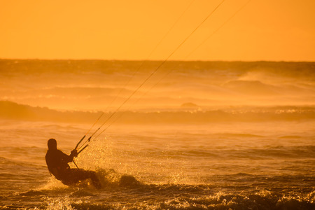 Single surfer at sunset on a calm oceanの写真素材