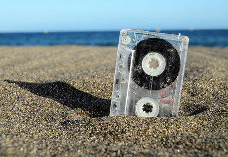 Ancient Retro Musicassette on the Sand near the Waterの写真素材