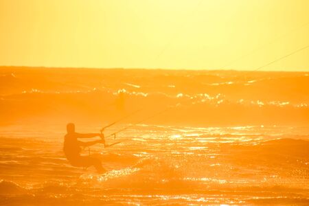 Single surfer at sunset on a calm oceanの写真素材