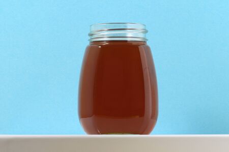 One Full Honey Jar on a Colored Backgroundの写真素材