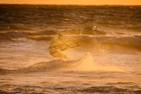 Single surfer at sunset on a calm oceanの写真素材