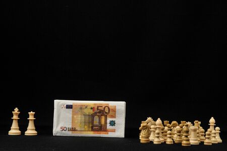 Money Strategy Concept White Chess and Currency on a Black Backgroundの写真素材