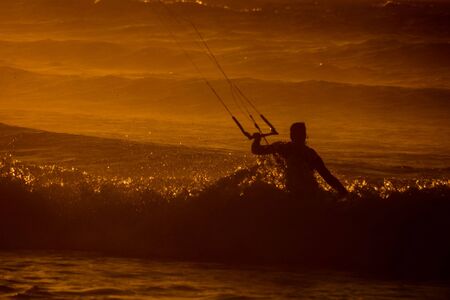 Single surfer at sunset on a calm oceanの写真素材