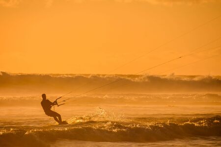 Single surfer at sunset on a calm oceanの写真素材