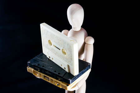 wooden dummy figurine and cassette audio audiocassette tape, music concept, puppet made of wood, art mennequin.Wooden Dollの写真素材