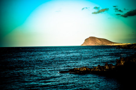 Sunset on the Atlantic Ocean with a Mountain in the Background El Medano Tenerife Canary Islands Spainの写真素材