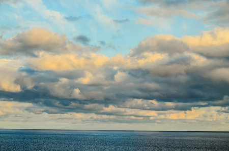 The sky is cloudy and the sun is setting. The clouds are white and the sky is blue