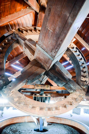 A wooden structure with a large, circular object in the center. The structure appears to be a part of a larger building, and the circular object seems to be a part of a clockの写真素材