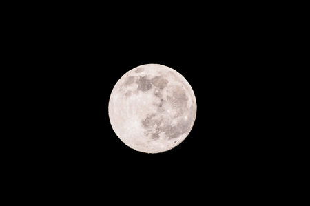 A large, round moon is in the sky. The moon is full and bright, and it is surrounded by darkness. Concept of calm and serenity, as the moon stands out against the black backgroundの写真素材