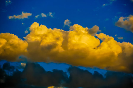 A large yellow cloud in the sky. The sky is blue and the clouds are white