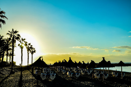 A beach with a lot of umbrellas and chairsの写真素材