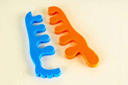 Two blue and orange hair brushes on a white background. The blue brush is on the left and the orange brush is on the rightの写真素材