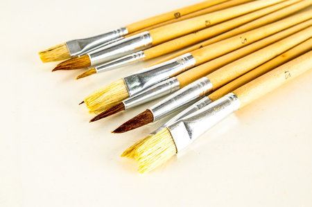A set of paintbrushes with different colors and sizes. The brushes are arranged in a row, with the larger ones on the left and the smaller ones on the rightの写真素材