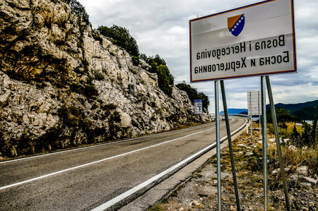 A foreign language sign is on a road in a foreign countryの写真素材