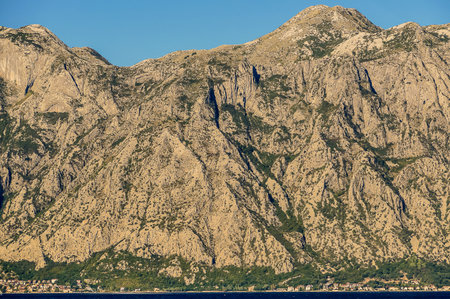 A mountain range with a rocky, barren landscape. The mountains are covered in a few trees, but the overall appearance is desolate and ruggedの写真素材