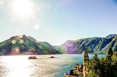 A beautiful mountain range with a lake in the foreground. The sun is shining brightly, creating a warm and inviting atmosphereの写真素材