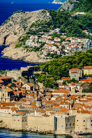A city with a large castle and a small town. The castle is on the left side of the image and the town is on the rightの写真素材