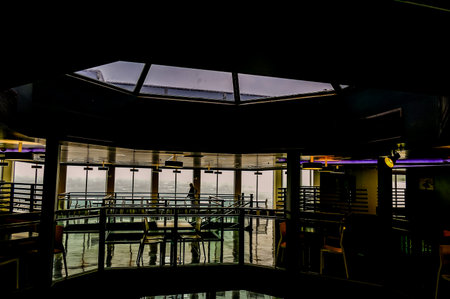 A large room with a glass ceiling and a person standing in the middle of it. The room is empty and the person is aloneの写真素材