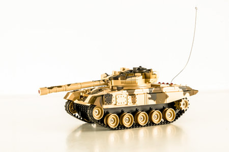 A toy tank with a remote control. The tank is camouflaged and has a remote control on itの写真素材