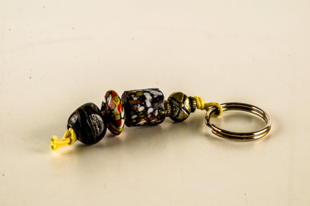 A key chain made of beads and a yellow string. The beads are of different colors and sizesの写真素材