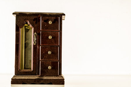 A wooden chest with a mirror on the front. The chest is empty and sits on a white surfaceの写真素材